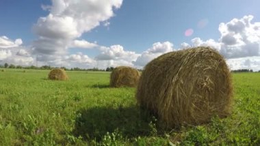 Ülke alanını haystacks ve bulutlar üzerinde yaz gökyüzü bulutlu. Timelapse 4k