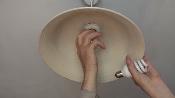 Changing an incandescent light bulb to CFL light bulb, 4K — Stock Video