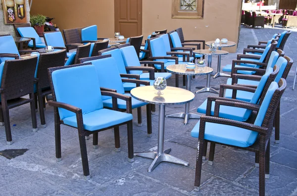 Linhas de cadeiras azuis e mesas metálicas em caffe — Fotografia de Stock