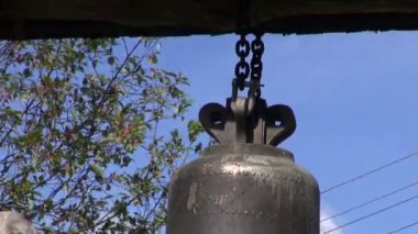 Ahşap park kapı çatı altında asılı metal çan