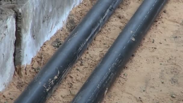 2 tuberías de calentamiento de agua negra recién puestas en una zanja — Vídeos de Stock