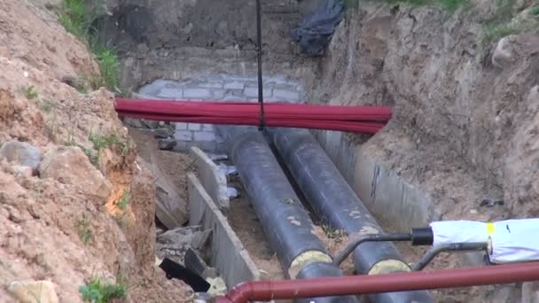 Dois tubos de aquecimento de água preta em uma vala que entra na casa — Vídeo de Stock