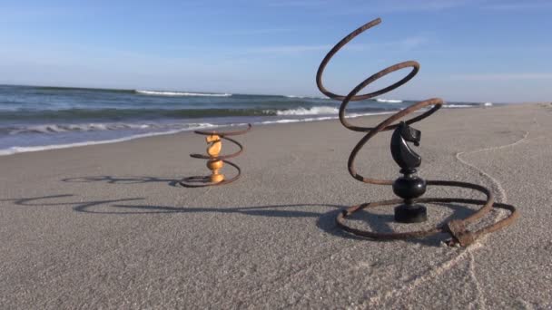 Две металлические пружины с двумя фигурками рыцаря на пляже — стоковое видео