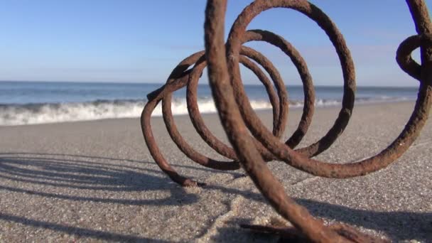 Seascape with old rusty metal spring  in  sand — Stock Video