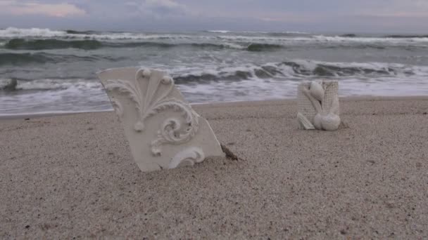 Скульптурная штукатурка, выброшенная на пляж в песок — стоковое видео