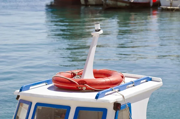 Roof of a boat with orange lifebuoy in  harbor — Stock Photo, Image