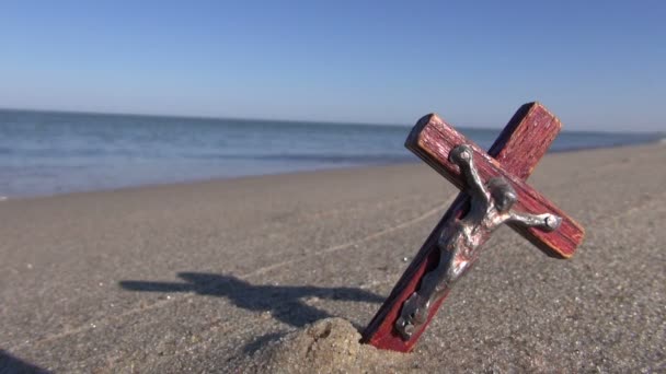 Океанський пляж зі старим дерев'яним хрестом розп'яття в піску — стокове відео