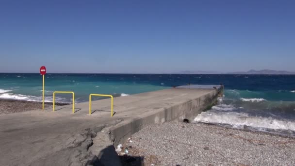 Хвилі котиться на пірсі на пляжі — стокове відео