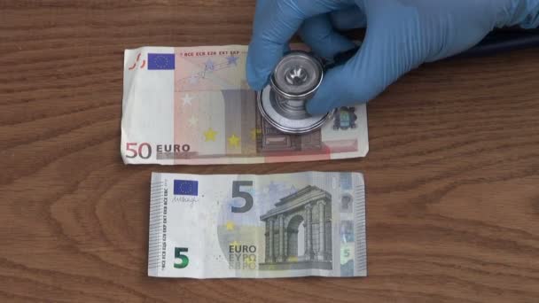 Homme économiste vérifier euros santé avec stéthoscope — Video