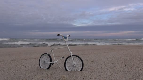 Kis játék kerékpár a tengerparton a tenger — Stock videók