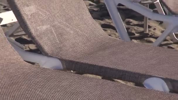 Lounges met parasols door de zee — Stockvideo