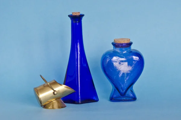 Duas garrafas de vidro azul com objeto de latão decorativo — Fotografia de Stock