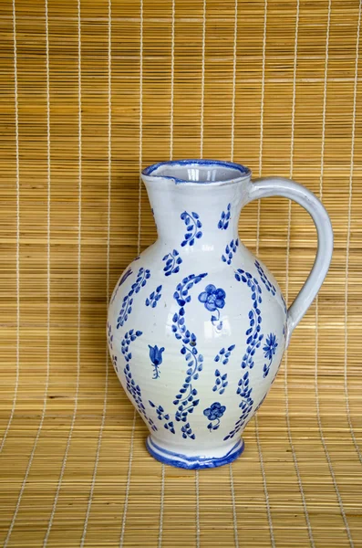 Clay jug on bamboo material background — Stock Photo, Image