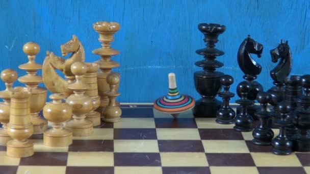 Colorful whirligig turning on chess board — Stock Video