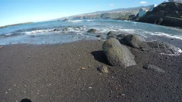 Vista de la playa de arena negra con colinas rocosas junto al océano, lapso de tiempo 4K — Vídeos de Stock