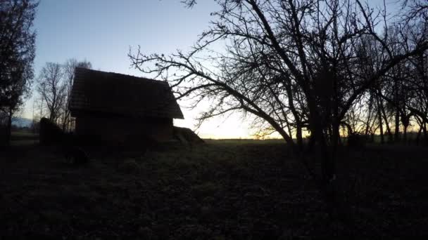 Paisagem com celeiro de barro velho e sol nascendo sobre campos rurais, lapso de tempo 4K — Vídeo de Stock