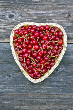 Kalp şeklindeki hasır sepet içinde kiraz
