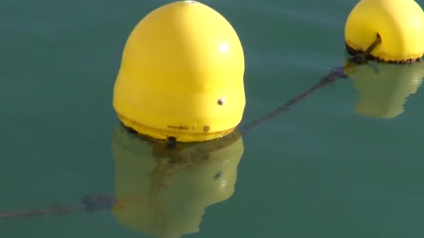 Gelbe sonnenbeleuchtete Bojen im Wasser — Stockvideo