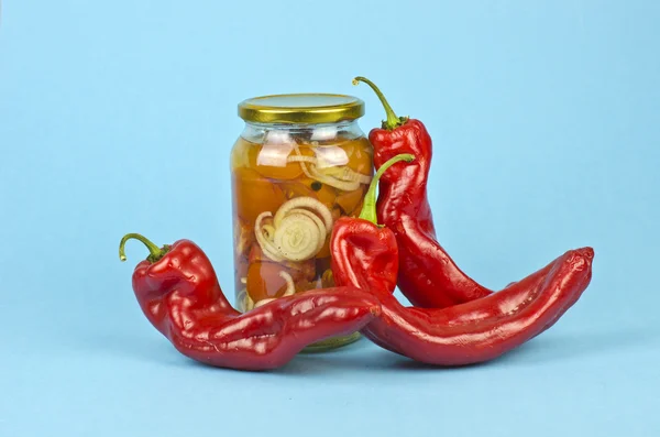 Tomates e pimentas marinados sobre fundo azul — Fotografia de Stock