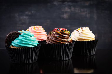 Koyu arka planda izole edilmiş lezzetli renkli kekler. Lezzetli kek.