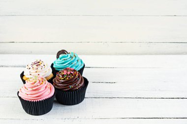 Ahşap arka planda izole edilmiş renkli kekler. Lezzetli kek.