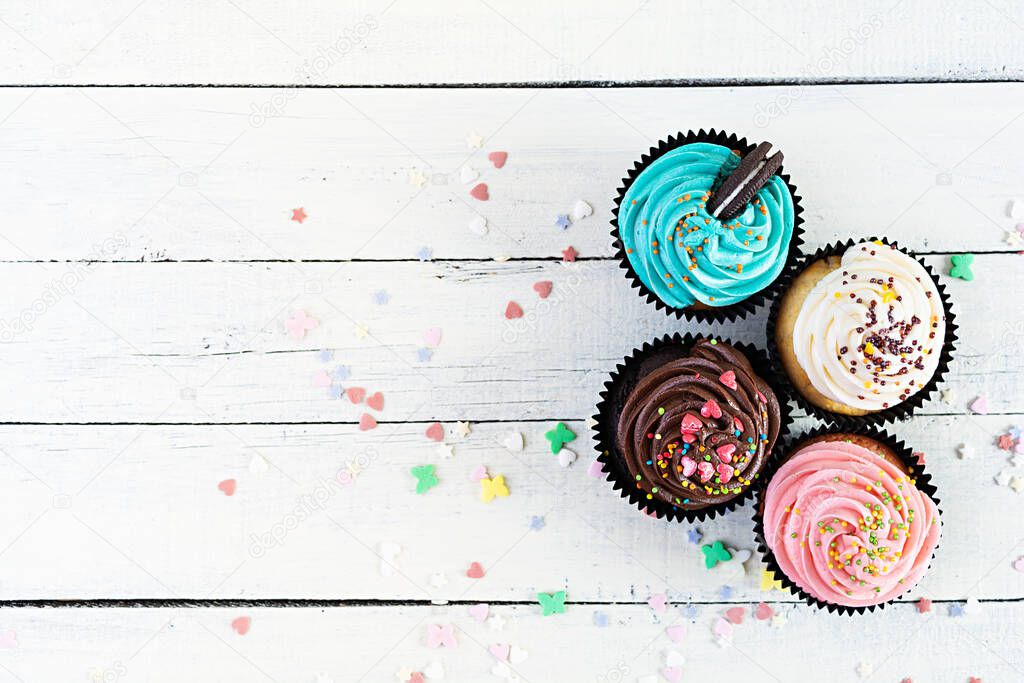 Tasty colorful cupcakes isolated on wooden background. Delicious cupcake