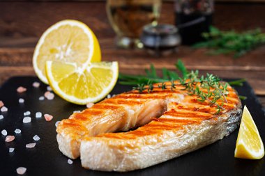 Taş tahtada ızgara somon balığı. Izgarada limonla kızartılmış tuzlu Atlantik somonu.