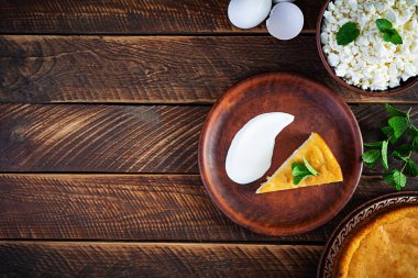 Kırsal ahşap arka planda ev yapımı süzme peynir güveci. Üst görünüm