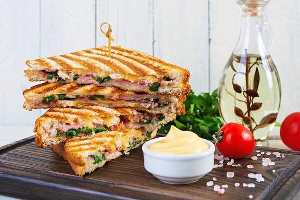 Club sandwich with ham, cheese, tomato, salad and chips