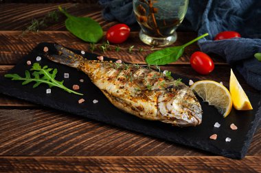 Ahşap arka planda ızgara dorado balığı. Baharatlı ve otlu kavrulmuş deniz ürünleri.