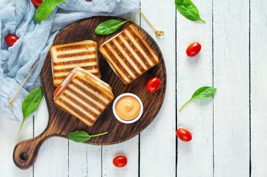 Jambonlu, domatesli, peynirli ve ıspanaklı sandviç. Izgara panini. Üst görünüm