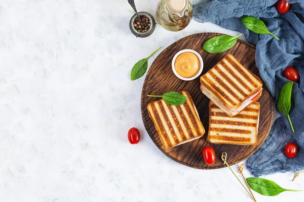 Jambonlu, domatesli, peynirli ve ıspanaklı sandviç. Izgara panini. Üst görünüm