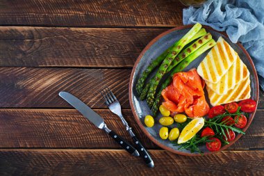 Kuşkonmazlı salata, ızgara halloumi peyniri, somon filetosu, domates, roka ve yeşil zeytin. Üst görünüm