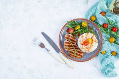 Izgara domuz etli pilav, domates ve yeşil otlar. Üst görünüm