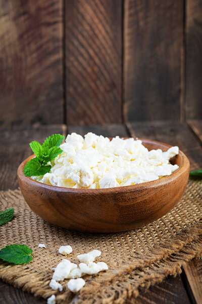 Bowl of cottage cheese on wooden background. Fresh homemade cottage cheese