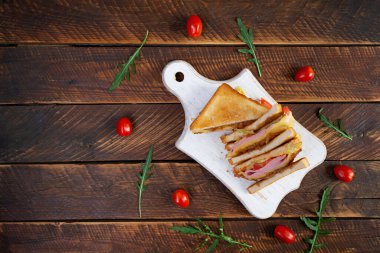 Jambonlu, domatesli, peynirli ve otlu kulüp sandviçi. Doldurulmuş kadehler