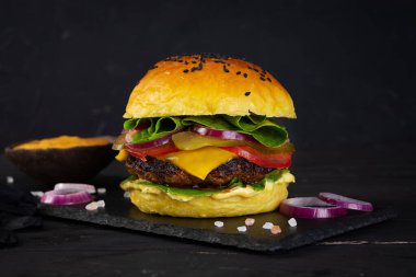 Erimiş peynir, sos ve taze malzemeyle sulu ızgara burger.