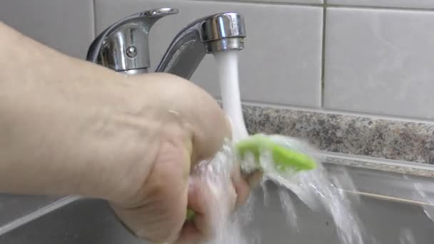 スポンジで手が皿を洗う準備をします 水の流れをタップ 手洗い用の食器洗い用スポンジ 蛇口水 — ストック動画