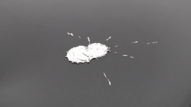 Erimiş metal damlaları düşüyor. Camdaki parlak teneke parçaları gümüş rengine benziyor..