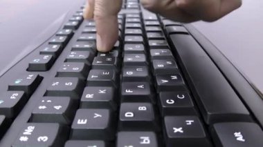 Kullanıcı klavyede yazı yazıyor. Parmaklar tuşlara basıyor, klavyeye bir program giriyor. Kaydırıcı atışı.