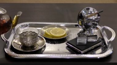 Sıcak siyah çay ve tepside bir bardak cam çaydanlık. Sabah çayı ve sigara..