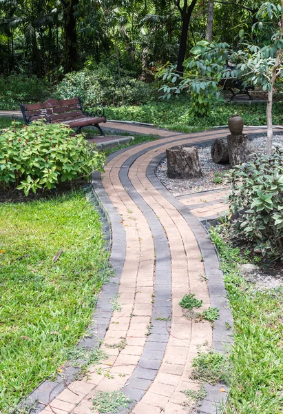Block tile walkway with wooden bench — Stock Photo, Image