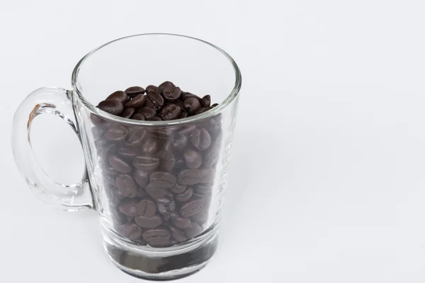 Vidrio transparente con granos de café tostados — Foto de Stock