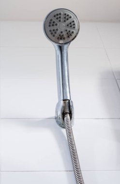 Eski krom duş banyonun duş kabinindeki fayans duvarının yanında asılı, sabah duş saatinden sonra, fotokopi alanının olduğu ön manzara. 