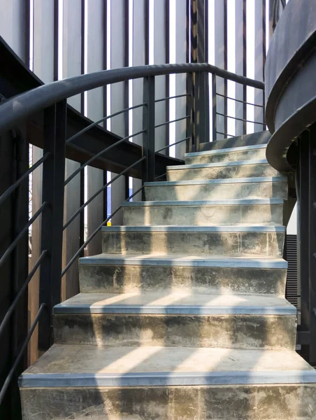 最上階までの金属製の手すり付きのコンクリート螺旋階段 鉄グリルを通して朝の光とモダンなスタイル コピースペース付きのフロントビュー — ストック写真
