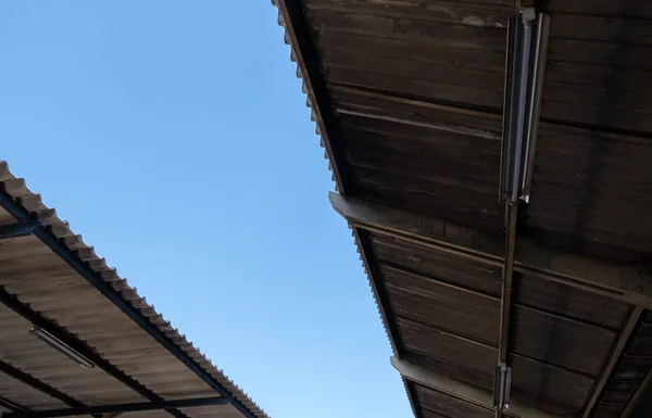 The lower view to the roof tile with the light bulb of the platform in the railway station, front view with the copy space.