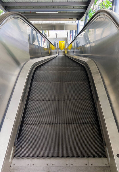 The empty modern escalator that is not yet in operation inside the suburban train station, go downstairs to the bus stop., front view with the copy space.