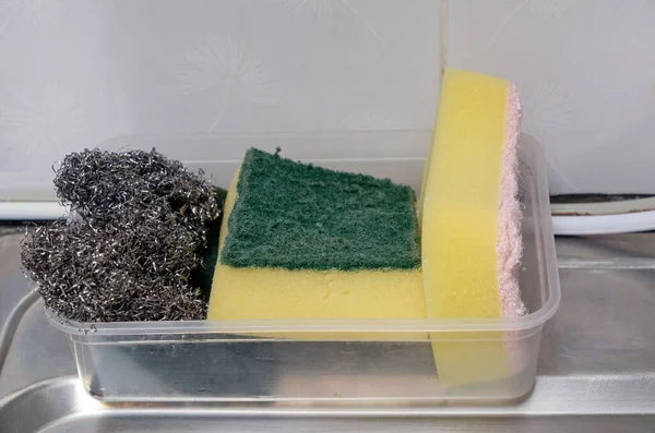 Bulaşık süngeri ve metal tencere temizleyicisi kullanımdan sonra kullanmak için plastik tepside, mutfaktaki lavabonun kenarında, fotokopi alanı için yazı tipi görünümünde..