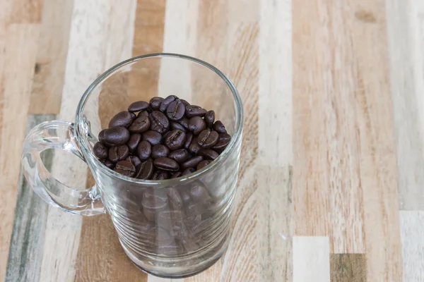 Vidrio transparente con granos de café tostados — Foto de Stock