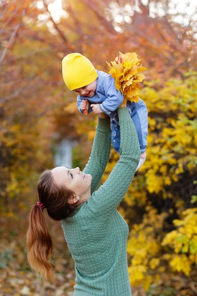 Jovem mãe feliz brincando com a pequena filha no parque de outono — Fotografia de Stock
